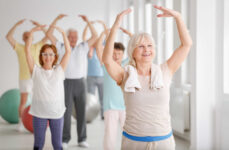 A group of seniors smiling and exercising together.